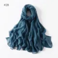 Close-up detail of lightweight solid blue scarf, featuring soft sheer fabric texture nicely. - 28