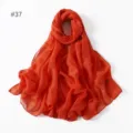Lightweight solid color polyester voile scarf detail view, soft draped fabric, orange. - 37
