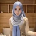 Detail shot of the shimmering gradient satin hijab scarf, showing smooth texture and beautiful drape. - Blue