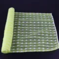 Long mesh sauna bath towel detail, showing textured green and white jacquard exfoliating fabric. - Yellow