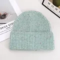 Green speckled knit beanie detail, thick winter warm pull-on wool hat closeup on white background. - Light Green