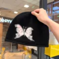 Black knitted beanie hat featuring a cute pink butterfly embroidery design, warm winter slouchy cap. - Adjustable / Black