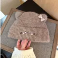 Brown knitted beanie with cute cat ears, bowknot, and embroidered face, warm winter hat for women. - Adjustable / Light Coffee
