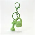 Mini fitness equipment keychain detail showing green dumbbell and kettlebell pendant design. - Green