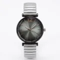 Close-up detail van het minimalistische quartz horloge met donkergrijze wijzerplaat en metalen band. - Grijs