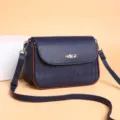 Borsa a tracolla trapuntata in pelle blu scuro con bordo marrone e formato quadrato. - Blu scuro