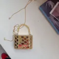 Gedetailleerd shot van gouden acryl strass clutch tas met kralenhandvat en metalen ketting. - 12.5*6.5*9 / Goud