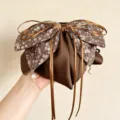 Nahaufnahme des retro Blumen Schleifen Haarklammers mit Satinschlieren und feinen Perlen. - Pferdeschwanz-Clip / Braun Blumenmuster