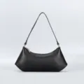 Close-up view of the black minimalist hobo shoulder bag showing its sleek curved silhouette. - Black