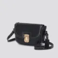Close-up detail of the black leather saddle bag featuring contrast white stitching and gold lock. - All Leather Black