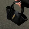 Black litchi grain leather handbag with gold lock clasp, stylish bucket tote for daily wear. - Black