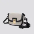 Detailed view of canvas saddle bag with gold lock and stylish contrast stitching. - Canvas Black