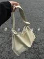 Detail view of the stylish faux leather knotted shoulder bag, soft texture and casual design. - White