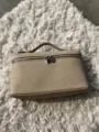 Detail view of the stylish litchi grain PU leather handbag vanity bag with secure zipper lock. - Gray
