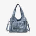 Detailed view of vintage washed denim tote bag featuring secure zippered pockets and buckle. - Aqua