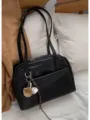 Detail view of black leather underarm tote bag with cute baseball glove charm on soft bed. - Black (No Pendant)