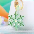Close-up detail view of a gorgeous snowflake rhinestone keychain with green crystals and gold ring. - Single OPP Bag Packaging / A820 Rhinestone Snowflake Green