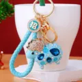 Detailed view of cute blue sheep keychain with sparkling rhinestones and golden metal ring. - Sky Blue Lucky Rope + Blue Rhinestone Sheep