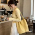 Detailed view of stylish yellow woven shoulder tote bag, large capacity, premium chic design. - Yellow