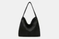 Close-up detail of the black faux suede shoulder bag showing soft texture and stitching. - Black Zipper Style