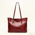 Detail shot of wine red leather tote bag showing fine texture and stitching, everyday style. - Burgundy