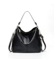 Close-up detail of black soft leather hobo shoulder bag with metal zipper and hardware. - Black