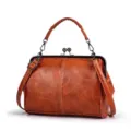 Retro brown leather kiss-lock handbag detail, vintage shoulder bag metal frame close-up. - Brown