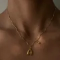 Detail shot of 18k gold plated stainless steel wave chain necklace with bubble letter pendant. - Letter A