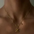 Nahaufnahme einer goldenen Wellenkette mit einem puffy Buchstaben Z Anhänger am Hals. - Buchstabe Z