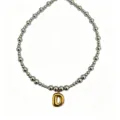 Close-up detail of silver-tone beaded necklace featuring a stylish gold bubble letter D pendant. - Letter D