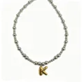 Close-up view of the trendy stainless steel beaded necklace with a gold puffy letter K charm. - Letter K