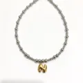 Stainless steel beaded necklace detail featuring a trendy gold bubble letter pendant stylish. - Letter N