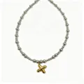 Close-up detail of the trendy stainless steel bead chain with a gold puffy letter pendant. - Letter X