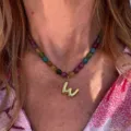 Colorful beaded necklace with gold letter pendant, fashion daily jewelry detail shot. - Letter W