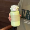 Portable minimalist stainless steel insulated water bottle with leather sleeve and straw. - Green