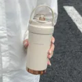 Insulated stainless steel coffee mug with portable handle and stylish metallic base. - Beige White (Ceramic Coated Liner)