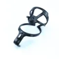 Detail view of a black lightweight plastic bicycle water bottle cage for mountain road bikes. - Black