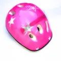 Close-up view of pink children safety helmet featuring white star patterns and vents. - One Size / Pink