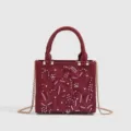 Burgundy satin handbag featuring exquisite floral embroidery and delicate white pearl details. - Burgundy