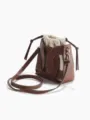 Detailed view of brown leather cutout bucket bag with beige canvas drawstring inner pouch. - Brown