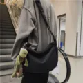 Trendy minimalist black crossbody bag with cute frog plush pendant for casual daily use. - Black With Pendant