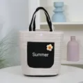 Straw woven tote bag, summer bucket handbag with black handles and floral pocket detail. - Black