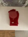 Detail van rood gebreide handschoenen met gestreepte omslag, wantfuntie en knopdetail. - Eén maat / Rood