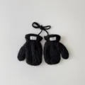 Vue détaillée de mitones tricotées noires pour bébé avec cordon et petite étiquette de marque. - Taille unique / Noir