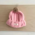 Gros plan détaillé d'un joli bonnet d'hiver en tricot rose pour enfant avec pompon. - Taille Unique (50-52cm) / Rose