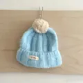 Bonnet en tricot pour enfants automne hiver, bonnet bleu clair avec pompon et jolie étiquette. - Taille Unique (50-52cm) / Bleu ciel