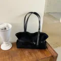 Zwarte schoudertas voor vrouwen van suède, stijlvolle shopper met handige gespdetailing. - Eén maat / Zwart