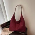 Detailopname van de vintage bordeauxrode suède schoudertas met zachte textuur en ruim ontworpen. - Eén maat / Bordeauxrood