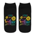 Close-up detail of black ankle socks featuring vibrant sunflower and motivational print. - One Size / A474