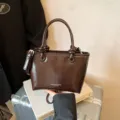 Brown patent leather handbag with top handles and stylish knot details, elegant crossbody. - No Pendant / Coffee